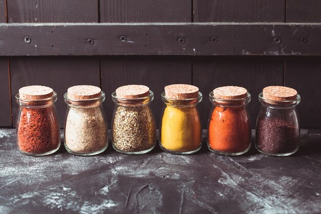 Photo various grinded spices in vintage glass bottles