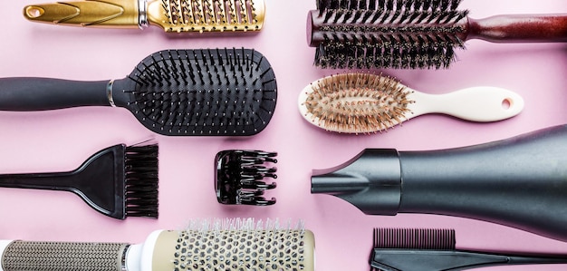 Various hair dresser tools on pink background with copy space