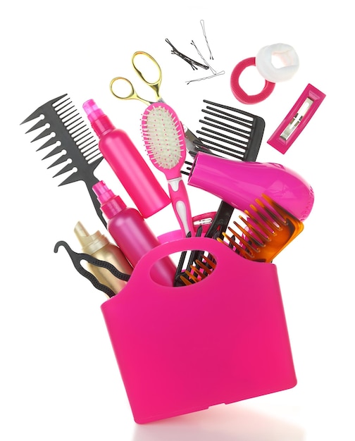 Photo various hairstyling equipment in shopping bag isolated on white