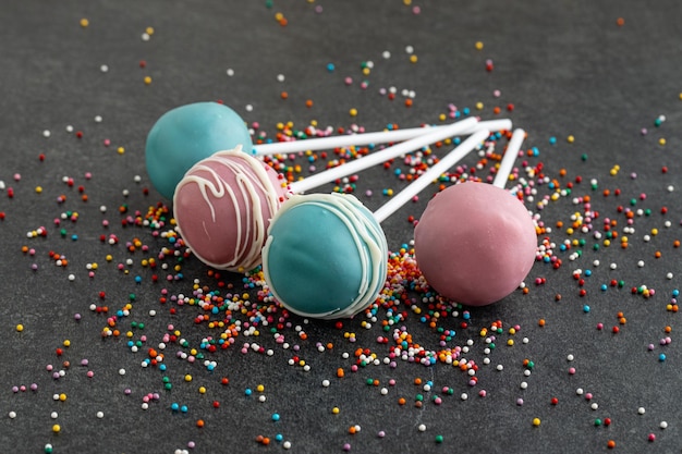 Various homemade cake pops on dark stone