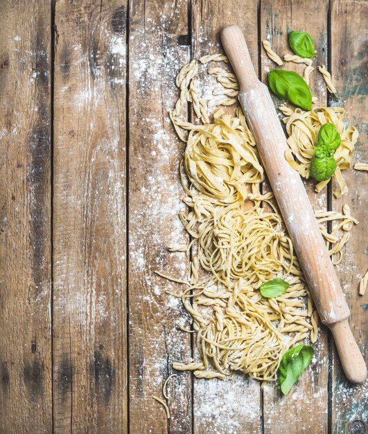 Различные домашние свежие сырые итальянские макароны и поршень