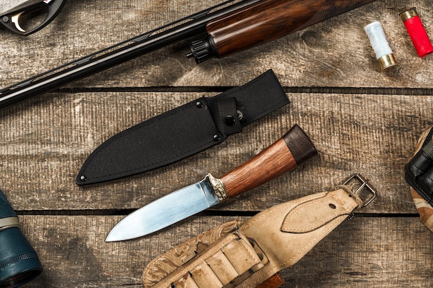 Various hunting equipment on old wooden background