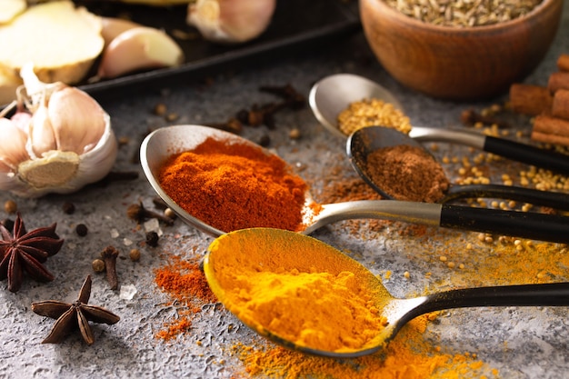 Photo various of indian herbs and spices for cooking closeup on a stone table