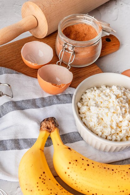 Vari ingredienti per la cottura con banana e cannella su sfondo grigio copia spazio vista dall'alto