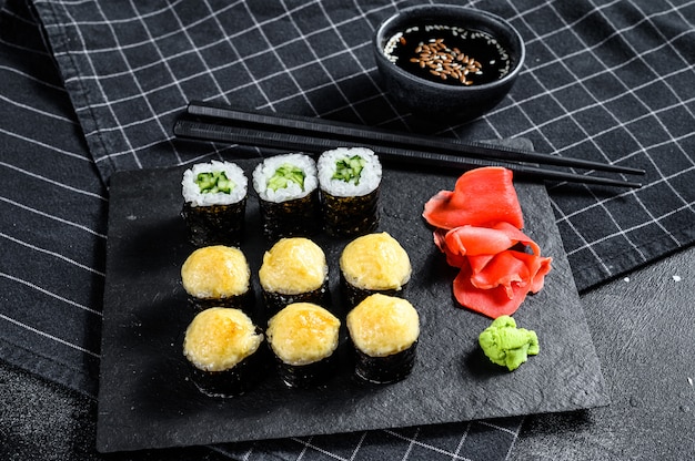 Various kinds of sushi served on black stone. Top view