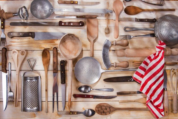 Foto diversi utensili da cucina appesi al legno