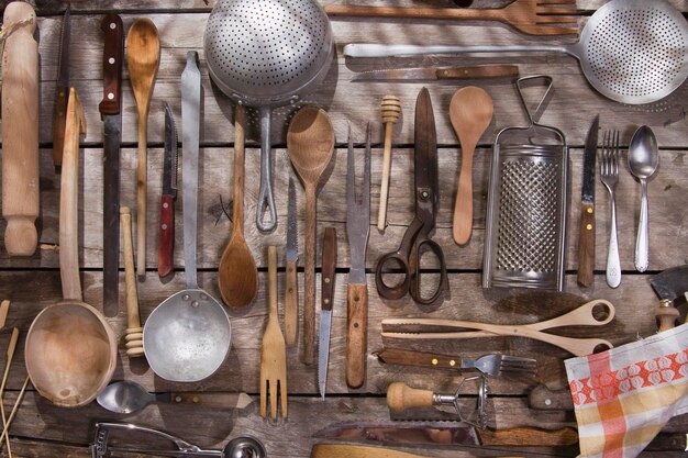 Foto diversi utensili da cucina appesi al legno