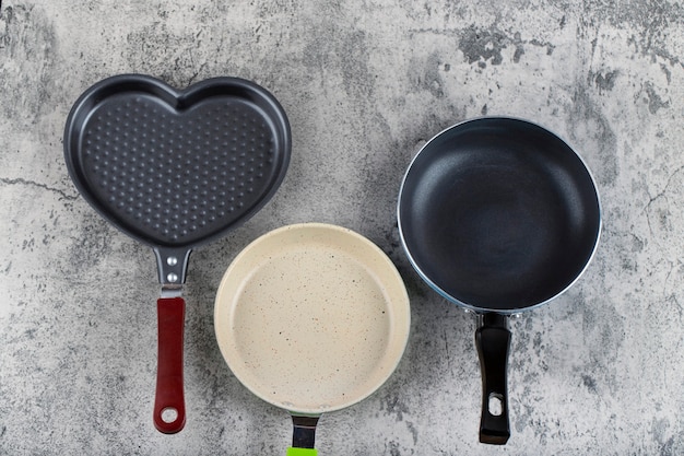 Various kitchen utensils placed on a stone background. 