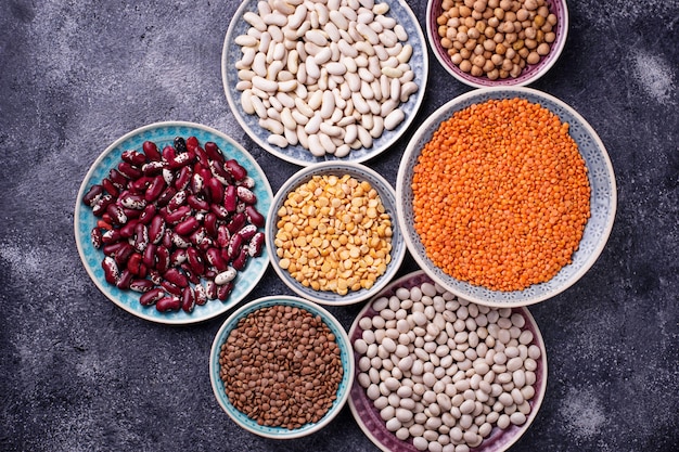 Vari legumi ceci, lenticchie rosse, lenticchie nere, piselli gialli e fagioli. messa a fuoco selettiva superiore