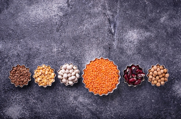 Various legumes. Chickpeas, red lentils, black lentils, yellow peas and beans. Selective focus. Top 