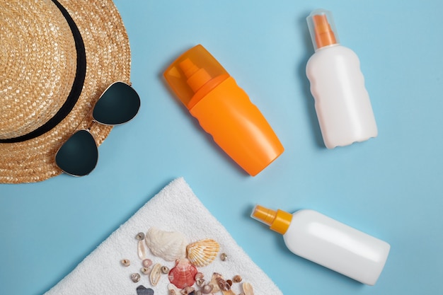 Various lotion bottles and creams for protection with seashells and hat