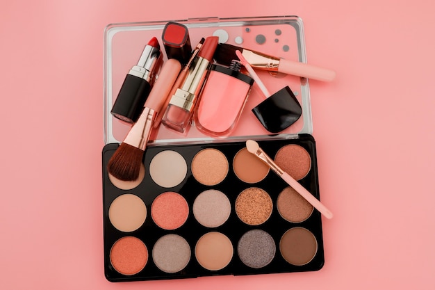 Различные продукты для макияжа на розовом фоне с copyspace.