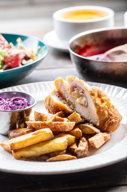 Various meals served on plates with cordon bleu with baked potatoes in the front.