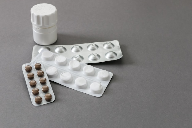 Varie pillole di medicinali su sfondo grigio