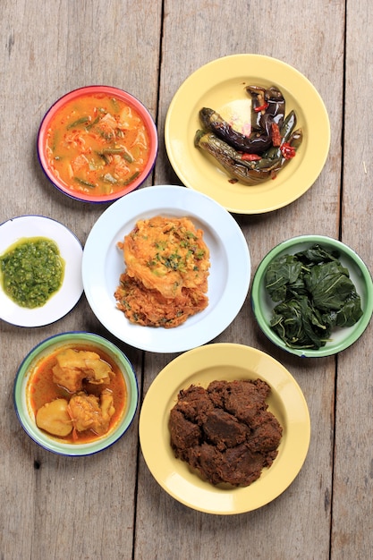 Various Menu of Padang Restaurant. Homemade Masakan Padang or Minang Cuisine on Rustic Background. Served on enamel Plate, Homemade Style nasi Padang