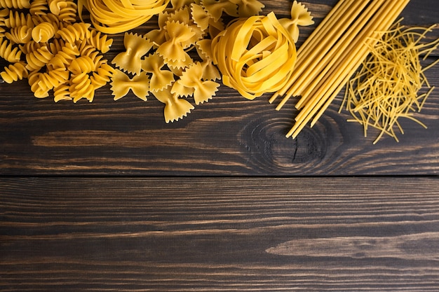 Various mix of pasta on dark wooden table. Italian food