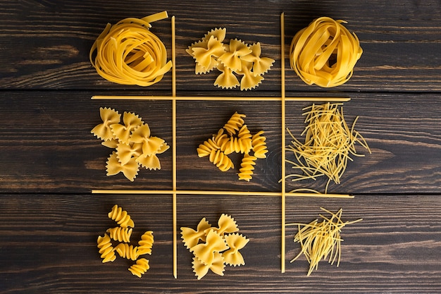 Foto vari mix di pasta sulla tavola di legno scuro. cibo italiano