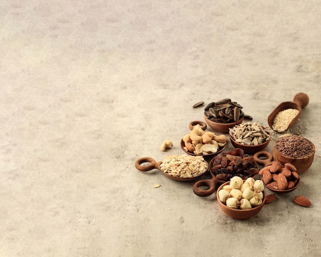 Различные орехи, семена, изюм на деревянной миске, концепция здорового питания диеты