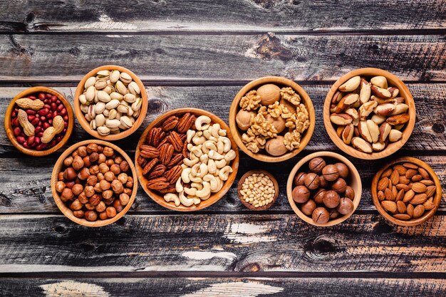 Various Nuts in wooden bowls top view