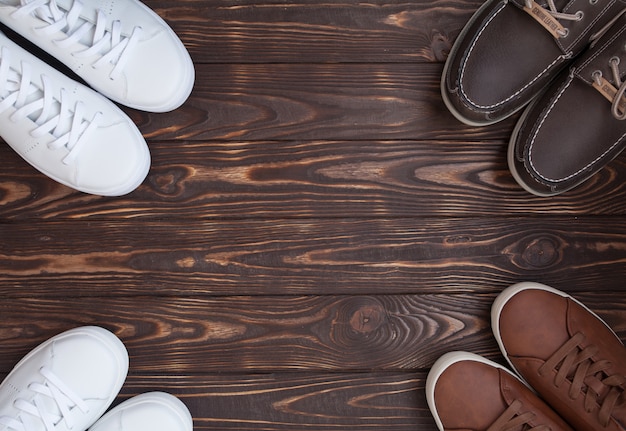 Various pairs of colorful sneakers laid on the wooden floor background