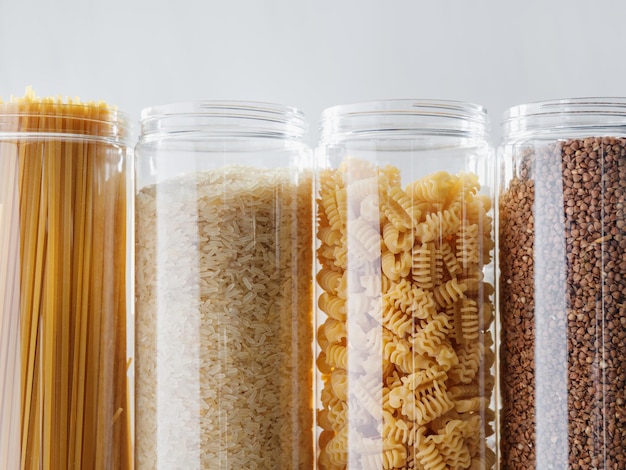 Various pasta and cereal grains in plastic jars for a long storage