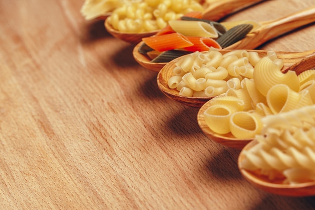 Various pasta on wooden spoons