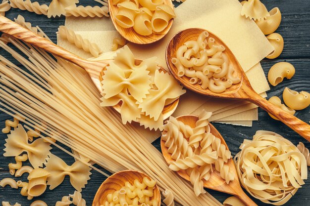 Various pasta on wooden spoons