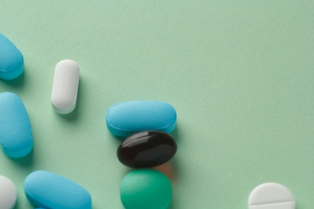 Various pills on light green background vitamins and medicine