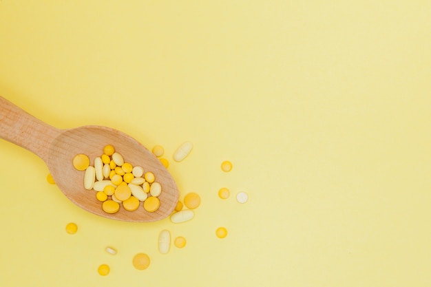 Various pills in a wooden spoon