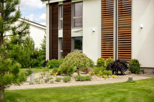 Various plants and stones in front of modern house front yard\
landscape design beautiful garden modern urban living residences\
with private courtyards green outdoor facilities lawn garden\
care