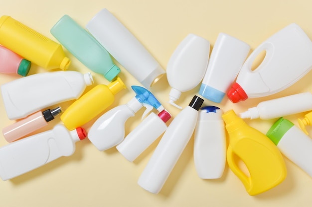 Various plastic bottles scattered on a yellow background