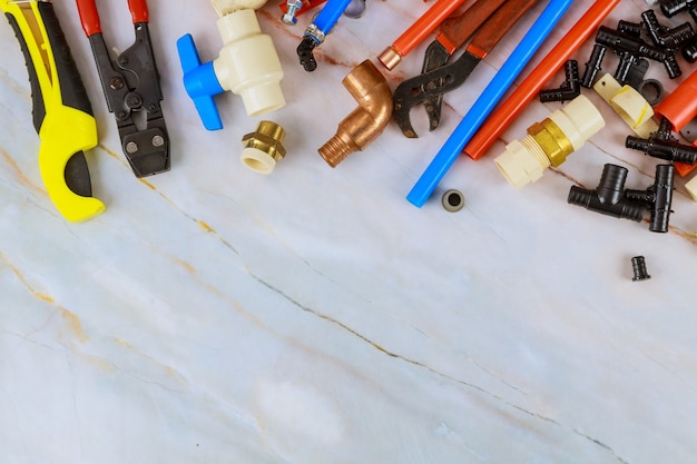 Various plumbers tools, pipe fittings on a home improvement plumbing materials including copper pipe, elbow joint, wrench and spanner.