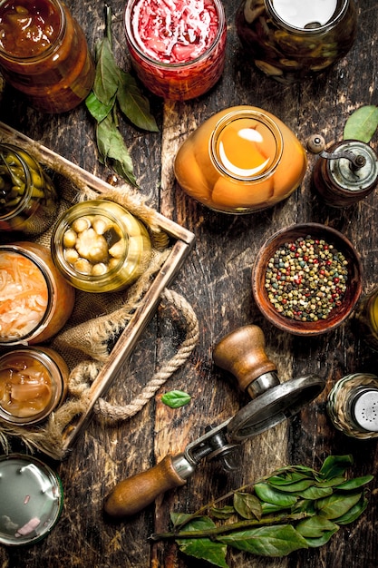 Photo various preserved vegetables and mushrooms with seamer and spices