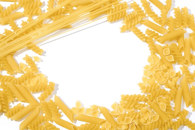 Various raw pasta on white background. Traditional Italian cuisine. Top view. Copy space, free space.