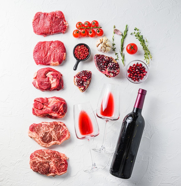 Various raw seasoned beef steaks with herbs and spices