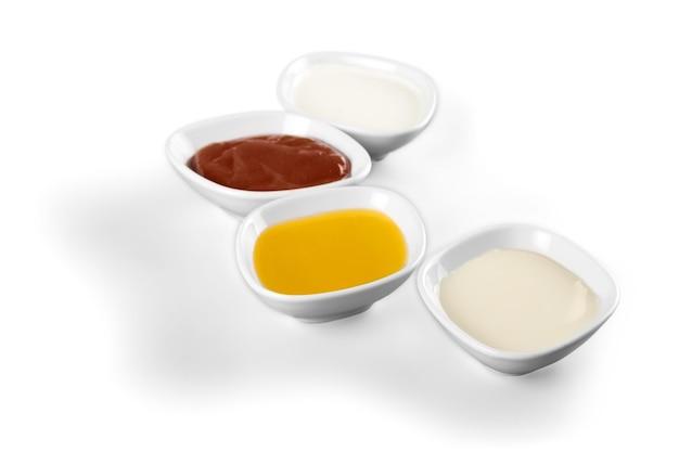 Various sauces in jars on wooden background, top view