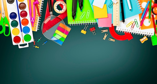 various school supplies arranged in a row on a dark background