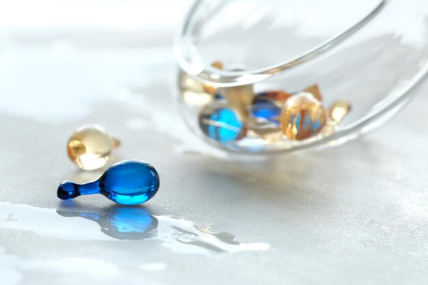 Various serum capsules for healthy skin routine Blurred background glass jar with the capsules on wet table