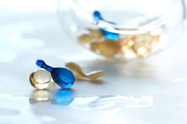 Various serum capsules for healthy skin routine Blurred background glass jar with the capsules on wet table