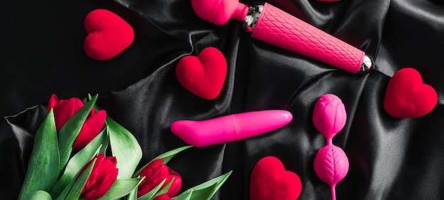 Различные секс-игрушки на черном фоне Реклама секс-шопа Вид сверху Весенние тюльпаны Горизонтальная широкая обложка с субтитрами фото copyspace