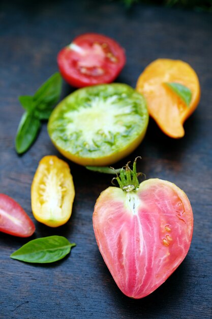 Various shapes and colors of tomatoes on a dark background