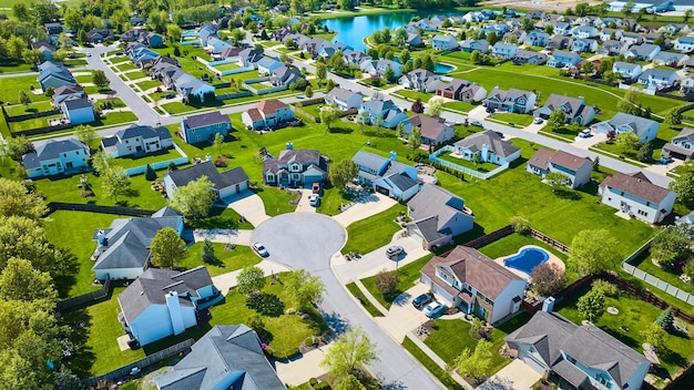 Various sized homes in large suburban neighborhood aerial and pond