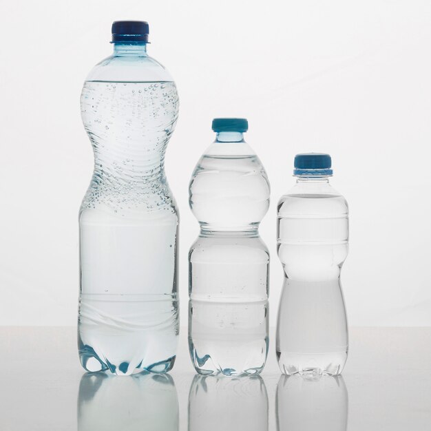 Varie dimensioni di bottiglie riempite di acqua vista frontale