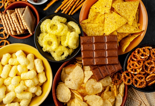 Various snacks and chocolate on a black table