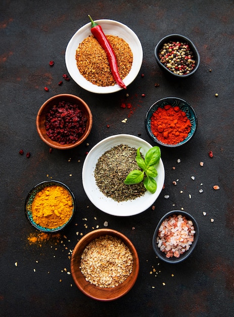 Various spices in a bowls on black concrete background