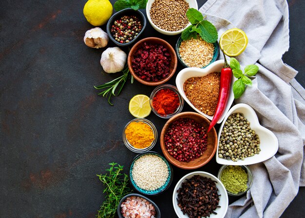 Various spices in a bowls on black concrete background