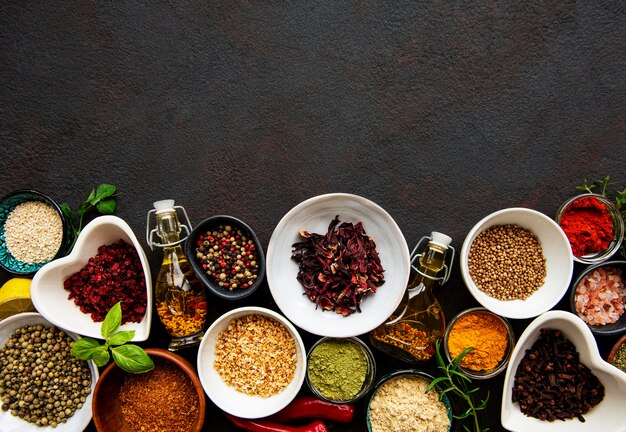 Various spices in a bowls on black concrete