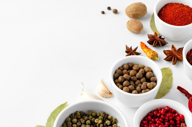 Photo various spices in a bowls on white background