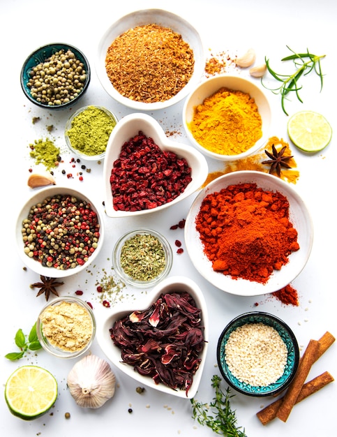 Photo various spices in a bowls  on white  surface top view copy space