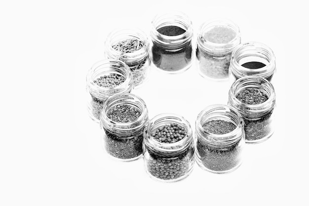 Various spices in jars on white background